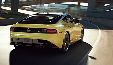 Nissan Z 2023 en jaune roulant sur une autoroute pour montrer ses performances.
