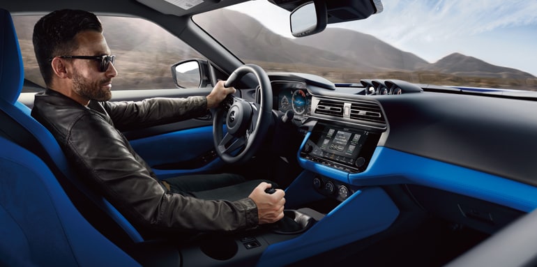 Une personne conduisant une Nissan Z 2024 avec intérieur bleu.