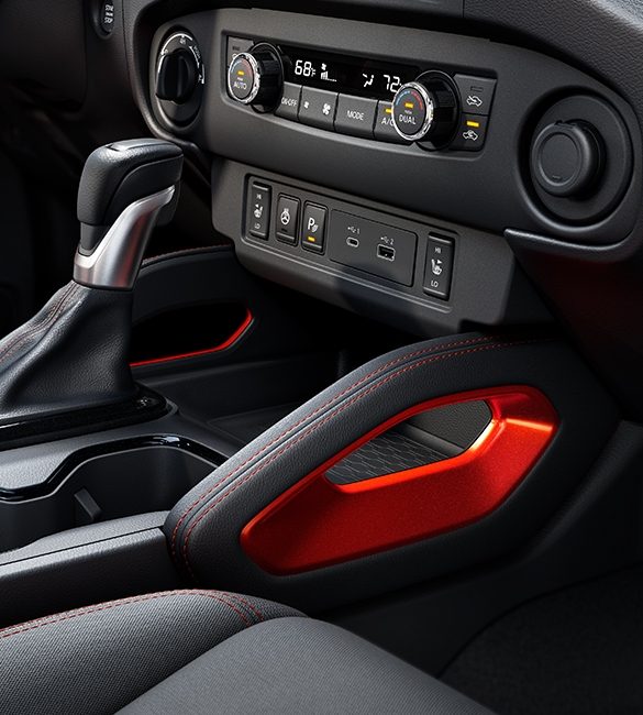 Console centrale avec des touches de rouge lave d’un Nissan Frontier 2023.