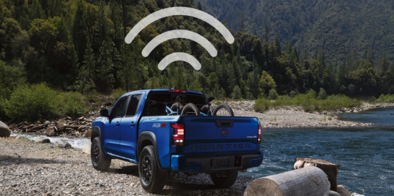 Symbole Wi-Fi suspendu au-dessus d’un Nissan Frontier 2024 bleu pour illustrer les capacités de point d’accès Wi-Fi du camion