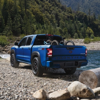 Un camion Nissan Frontier 2024 bleu garé près d’une rivière
