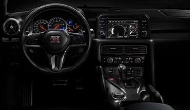 Vue intérieure de la Nissan GT-R montrant le tableau de bord de style poste de pilotage.