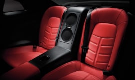 Vue intérieure de la Nissan GT-R montrant les sièges et le système de caisson d’extrêmes graves de la chaîne audio Bose haut de gamme.