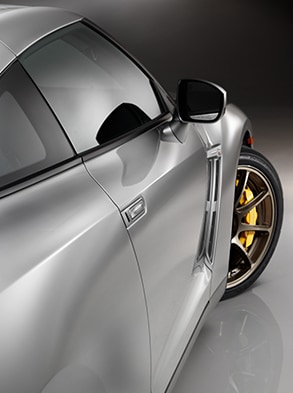 Vue latérale de la Nissan GT-R 2024 en couleur argent supérieur quatre couches unique.