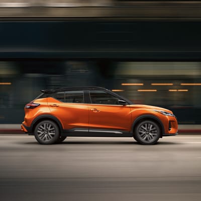 Nissan Kicks 2024 orange roulant à toute vitesse dans la rue, soulignant l’économie de carburant