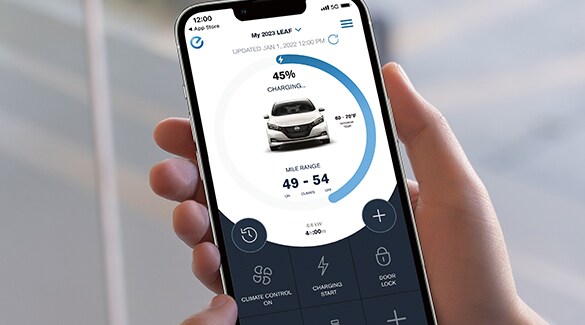 Téléphone intelligent affichant l’écran de l’état de recharge de la voiture dans la Nissan LEAF 2023