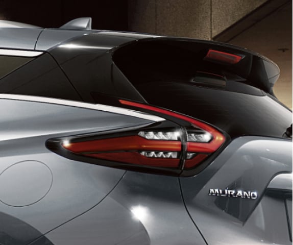 Vue inclinée de l’arrière d’un Nissan Murano 2024 gris mettant en évidence les feux arrière en forme de boomerang
