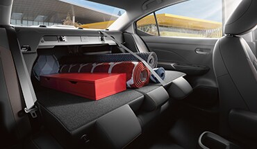 Illustration de la Nissan Versa 2023 montrant les sièges arrière rabattus pour accueillir le chargement.