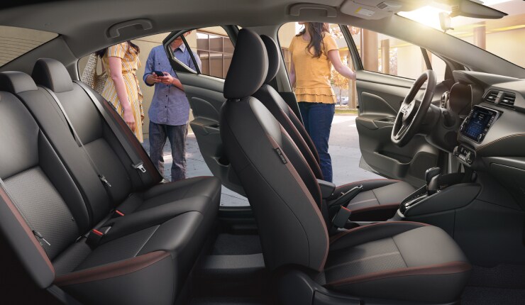 Illustration de la Nissan Versa 2023 montrant l’intérieur du côté passager alors que des personnes prennent place, et mettant l’accent sur les sièges arrière.