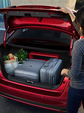 Illustration de la Nissan Versa 2023 montrant le grand coffre contenant des sacs d’épicerie et des bagages.